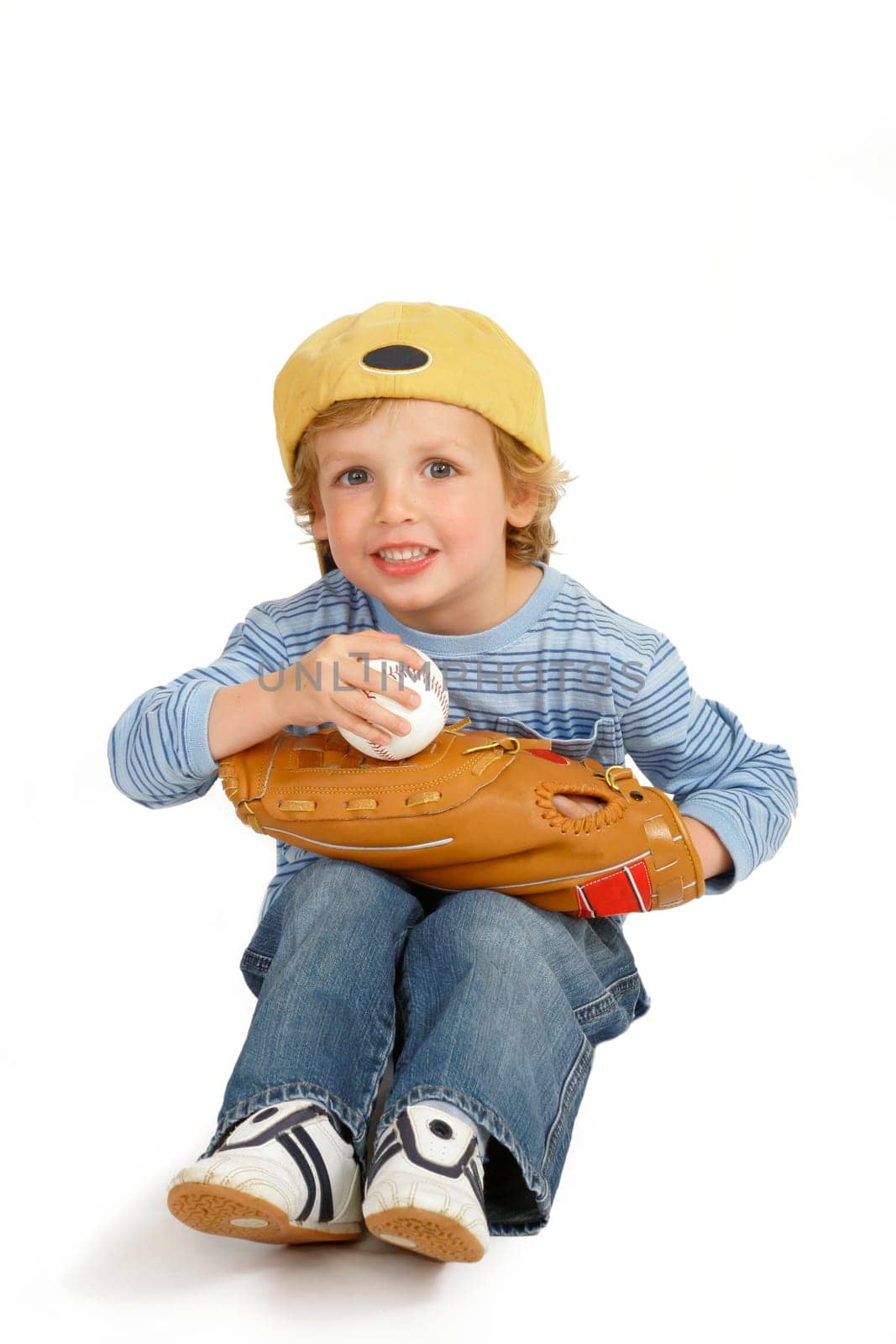 Isolated studio shot with a drop shadow showing a cute little blond boy dressed and ready to play baseball