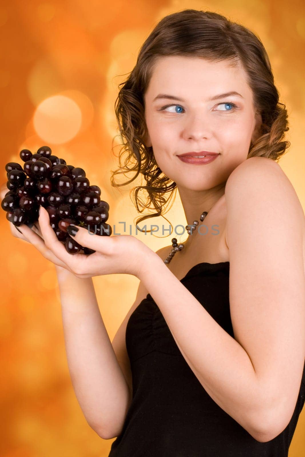 glamorous girl holding some grapes in her hand
