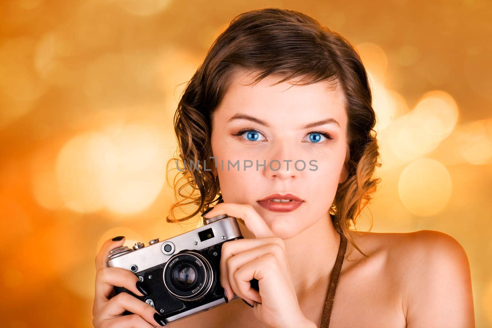 a glamorous girl in the evening dress holding a camera
