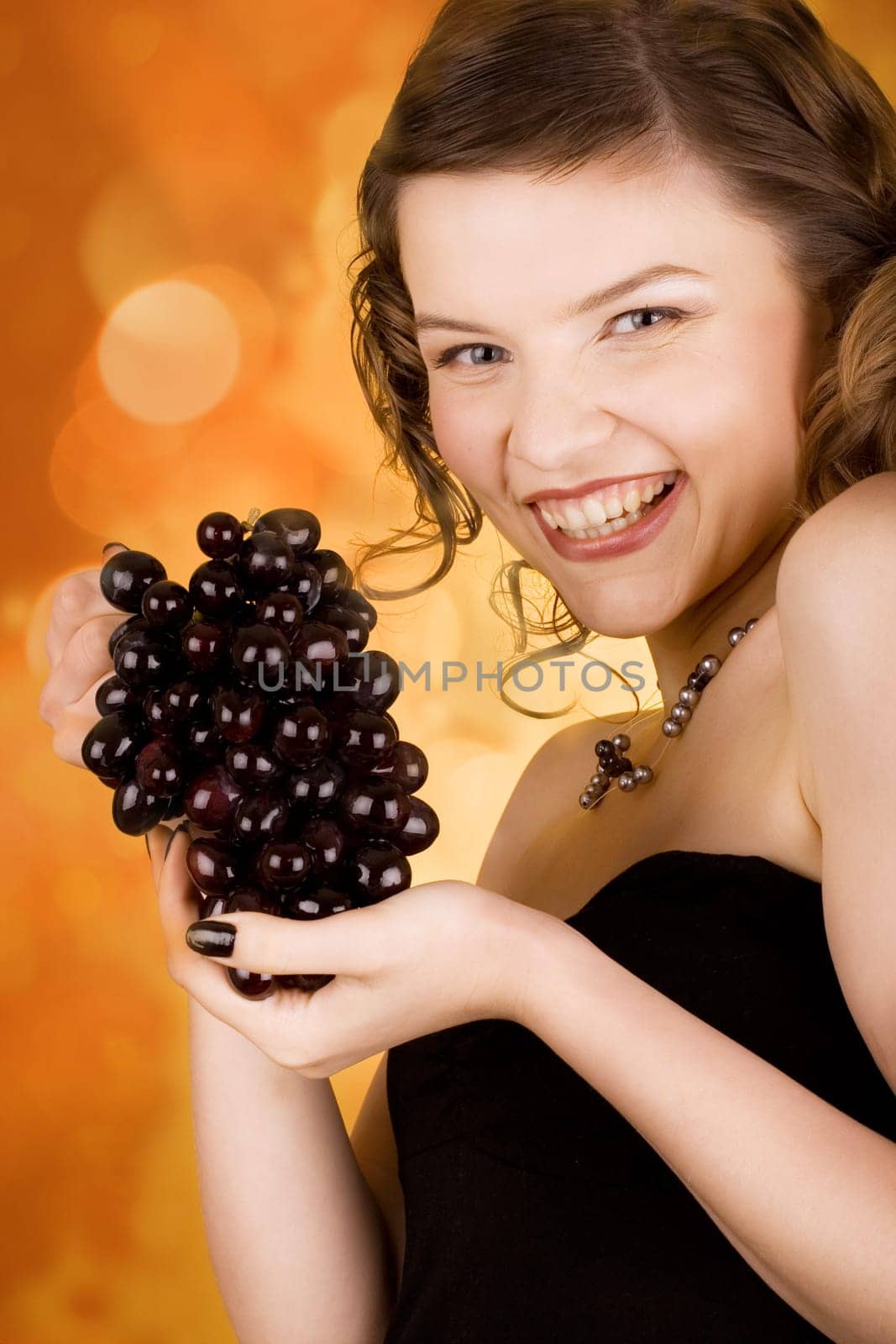glamorous girl holding some grapes in her hand