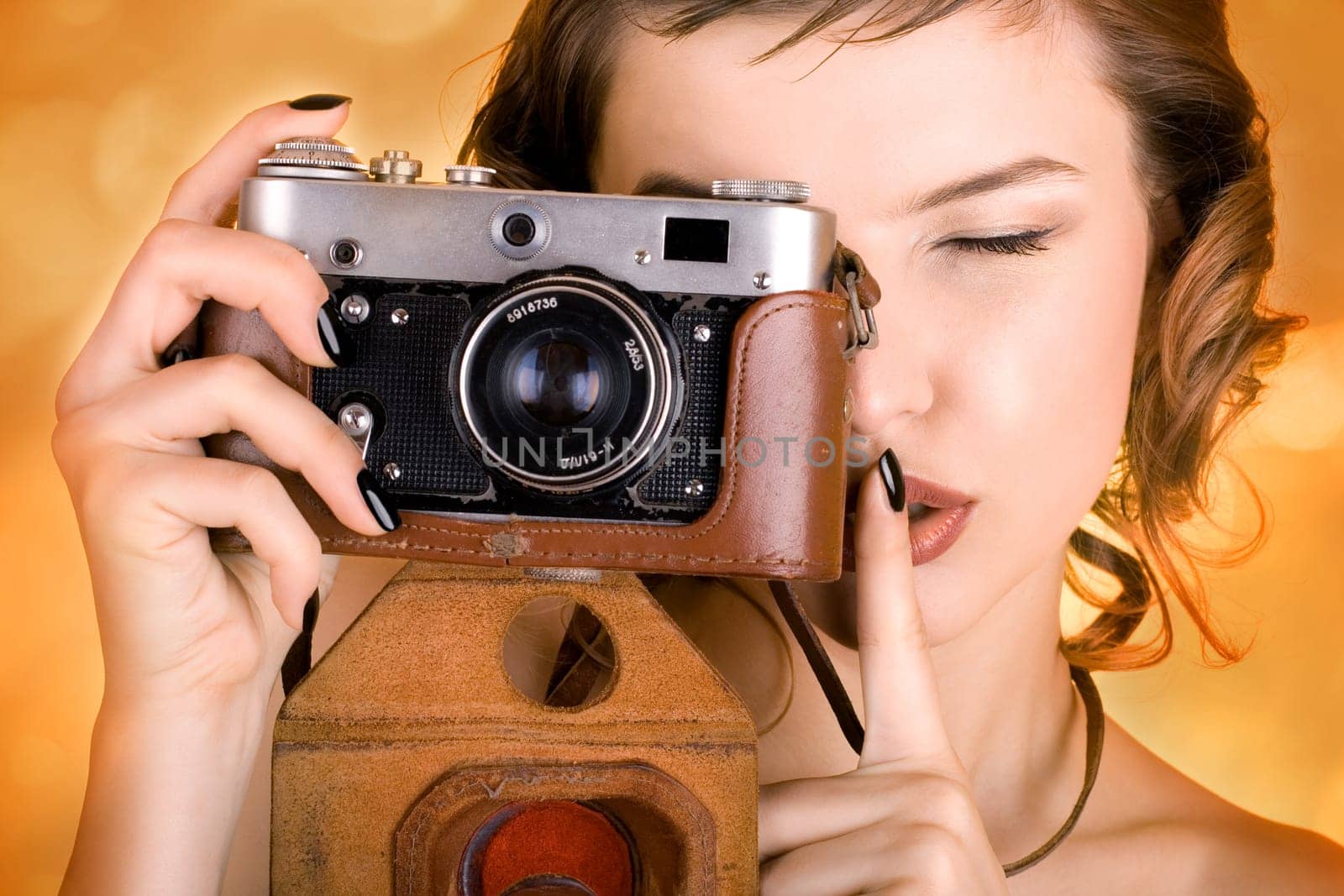 a glamorous girl in the evening dress holding a camera