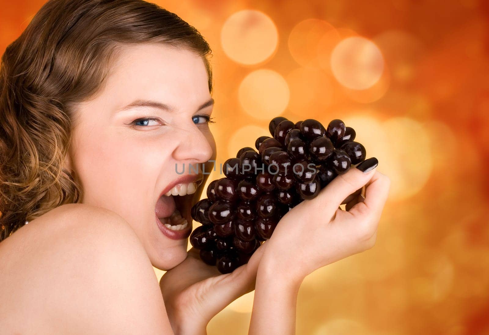 glamorous girl holding some grapes in her hand