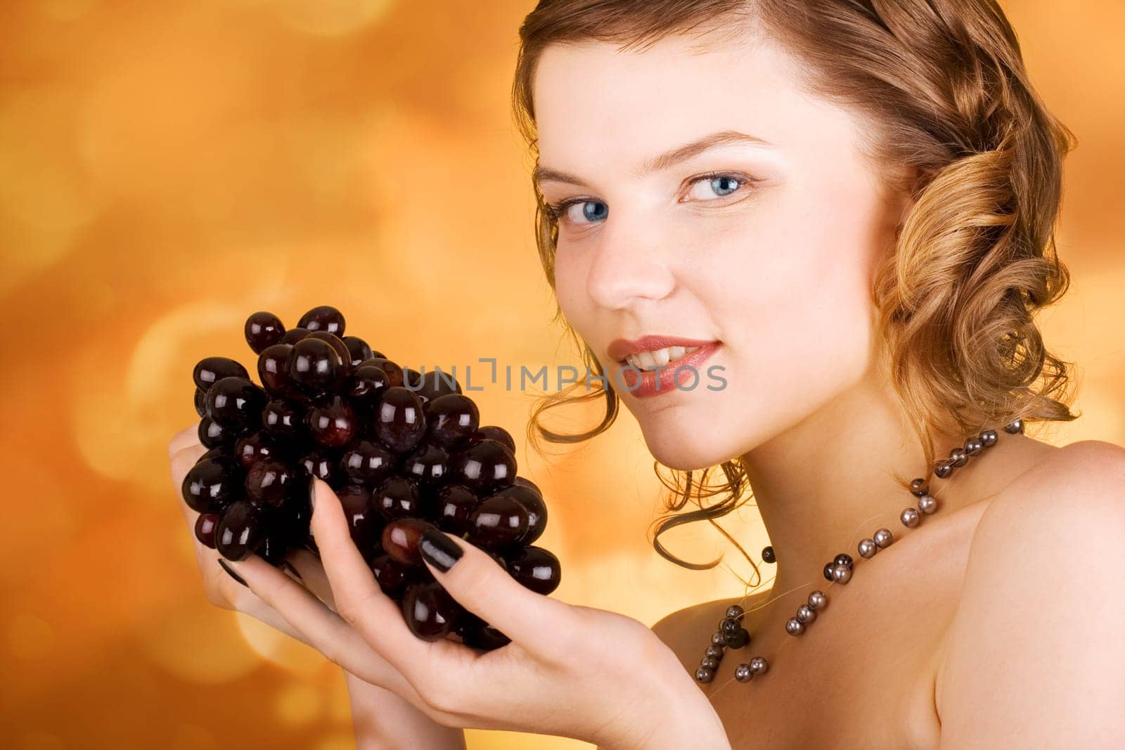 glamorous girl holding some grapes in her hand