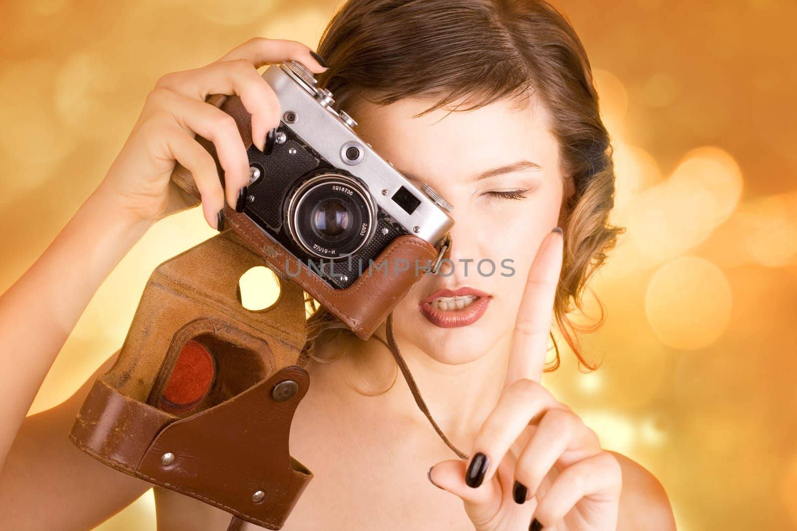 a glamorous girl in the evening dress holding a camera