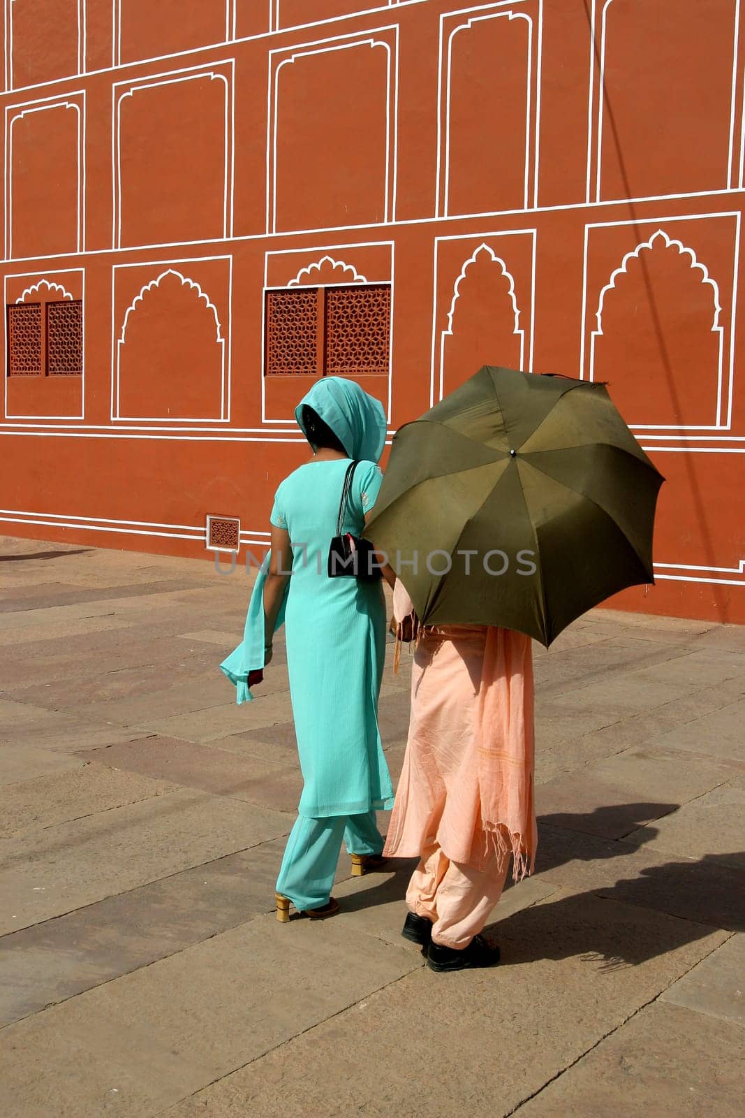 Traditional dressed Indian women walking through the Red Palace
