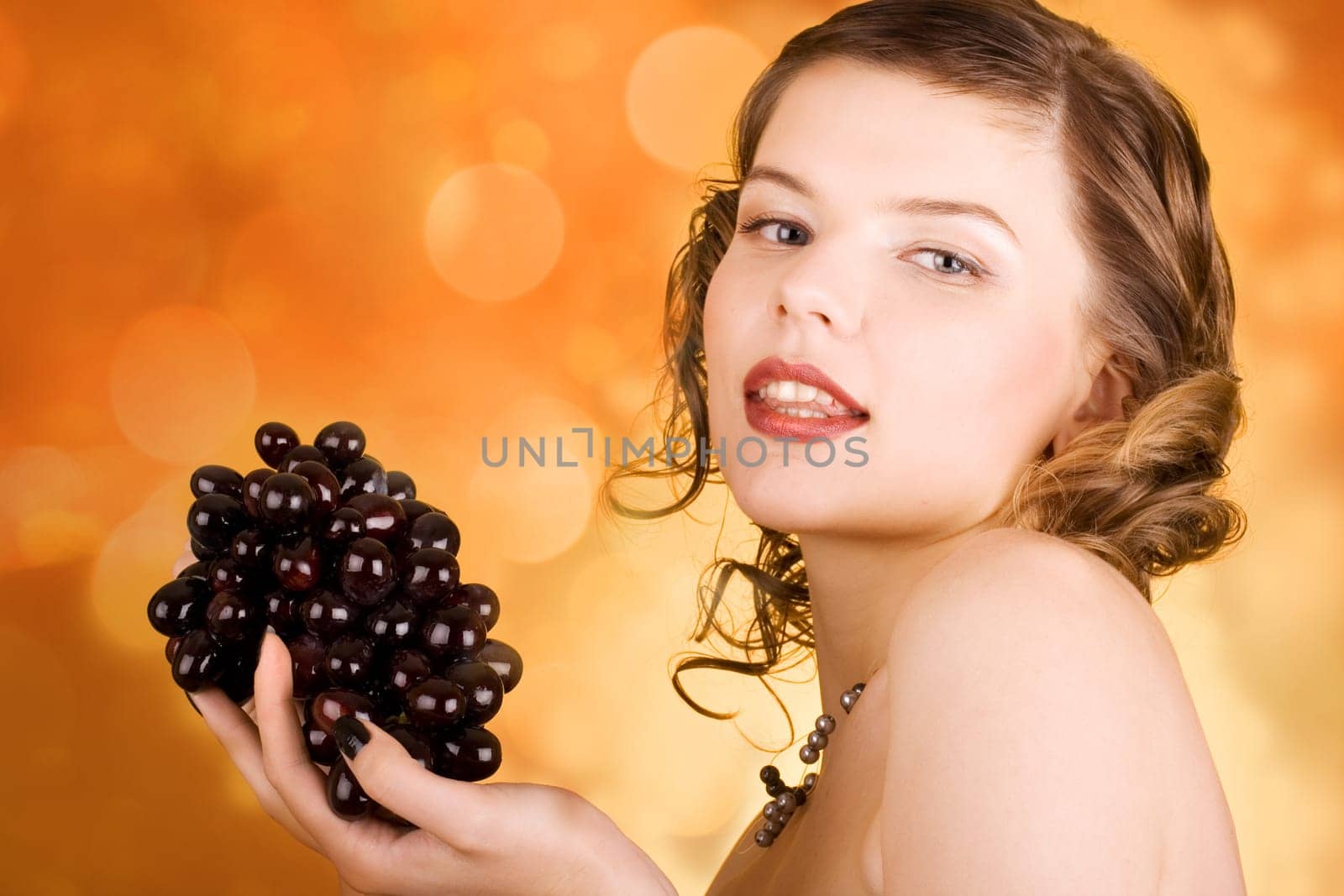 glamorous girl holding some grapes in her hand