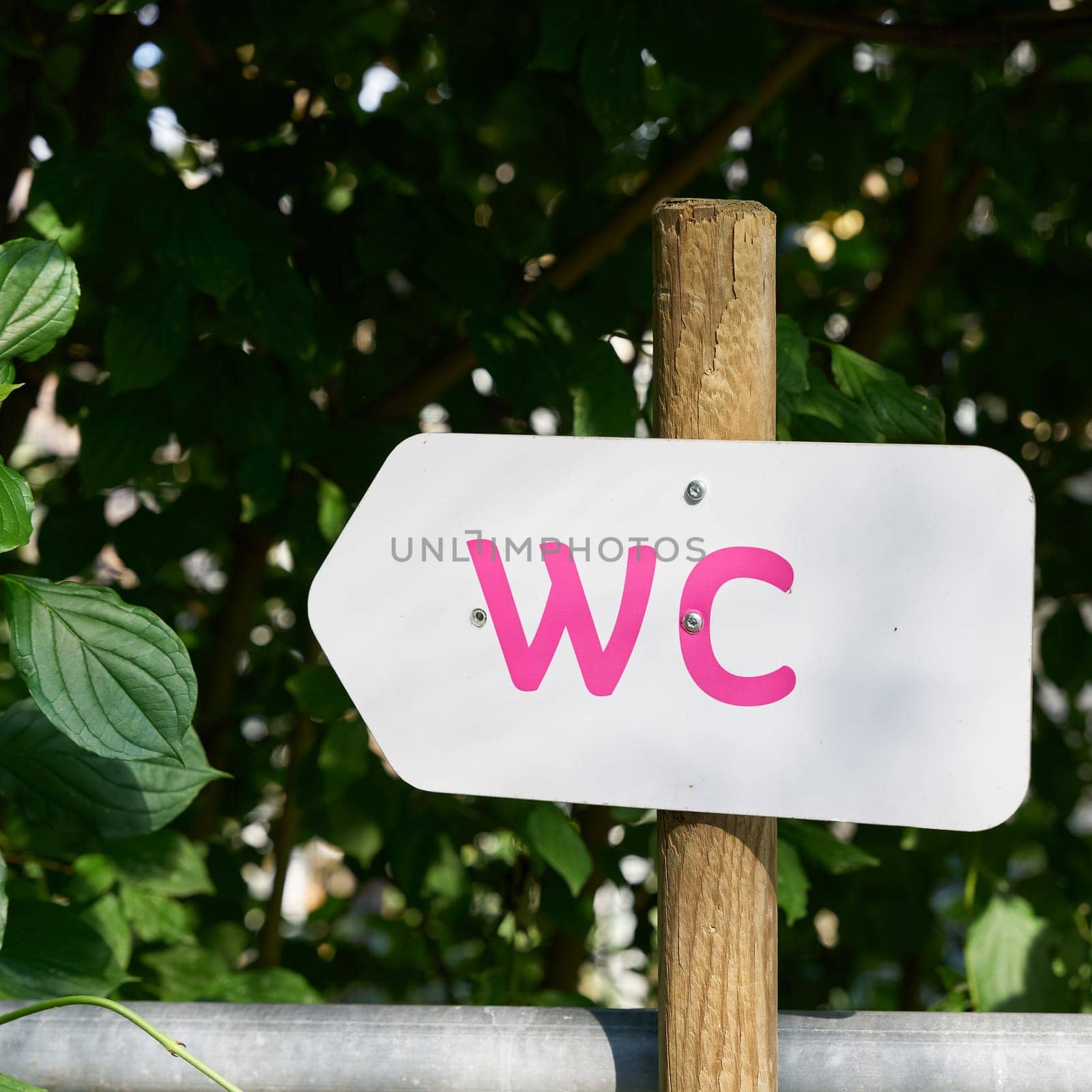 Directional arrow pointing to a toilet in a public park in France