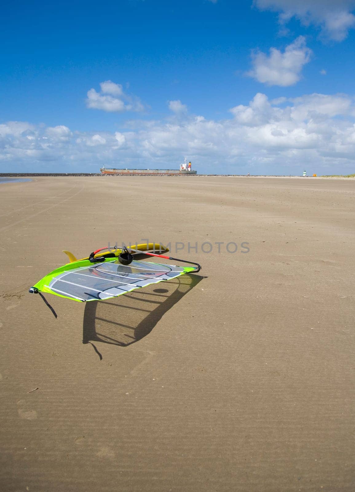 Cargo ship passing a beach with a surfboard on her way to the sea