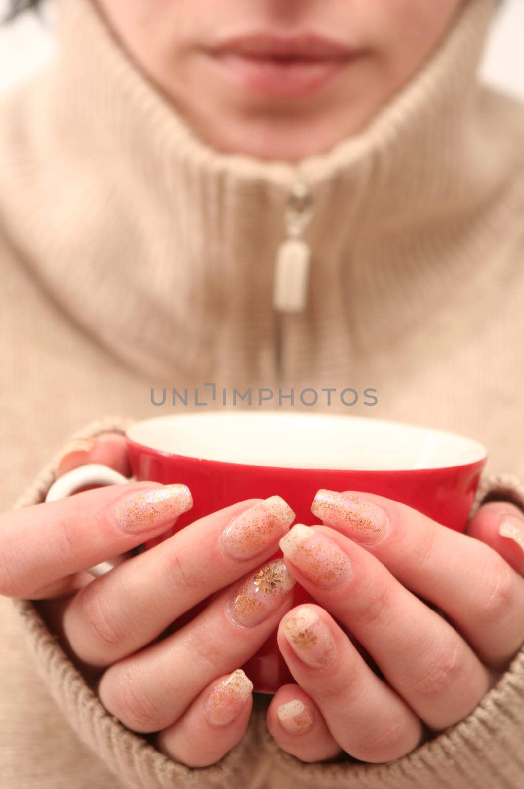 Red cup in female hands on a white background