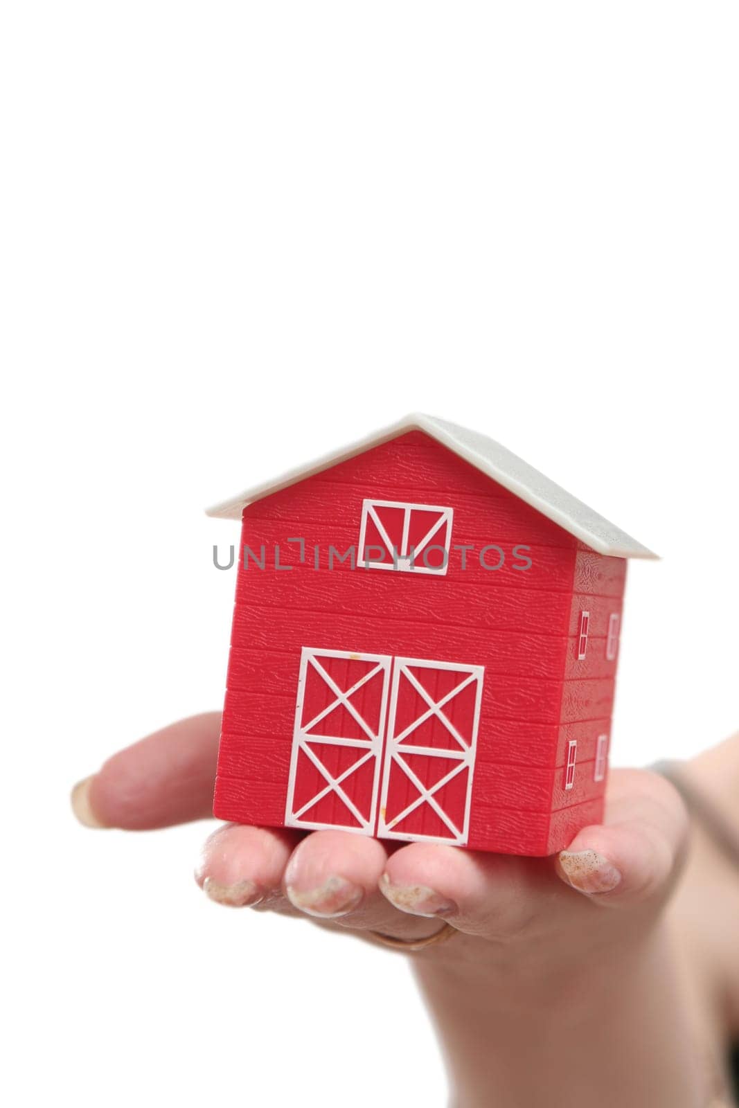 The red house is in a female hand on a white background