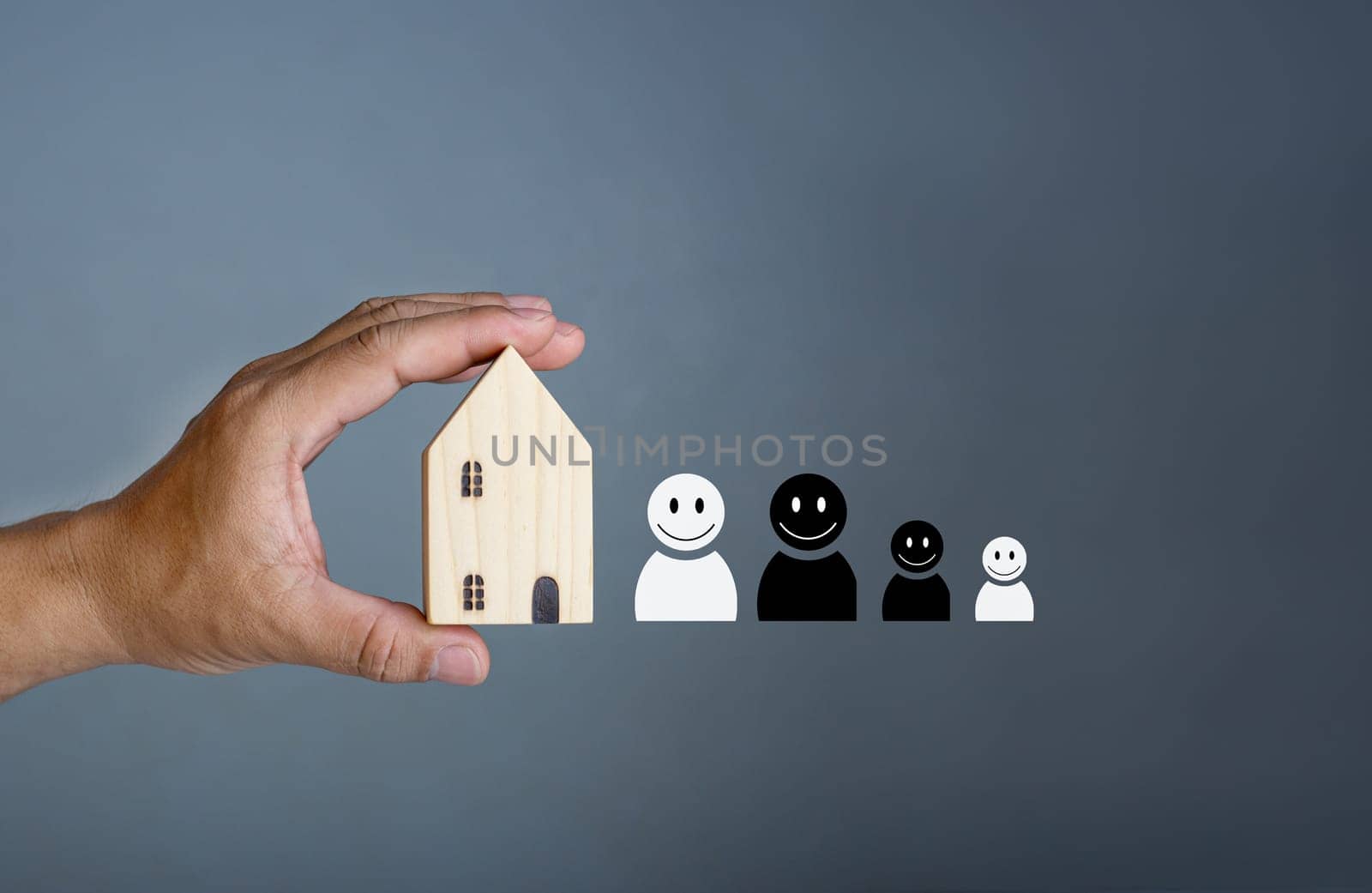 Happy house concept. Hand holding a smiling model house. Indicates happiness and love in the house.