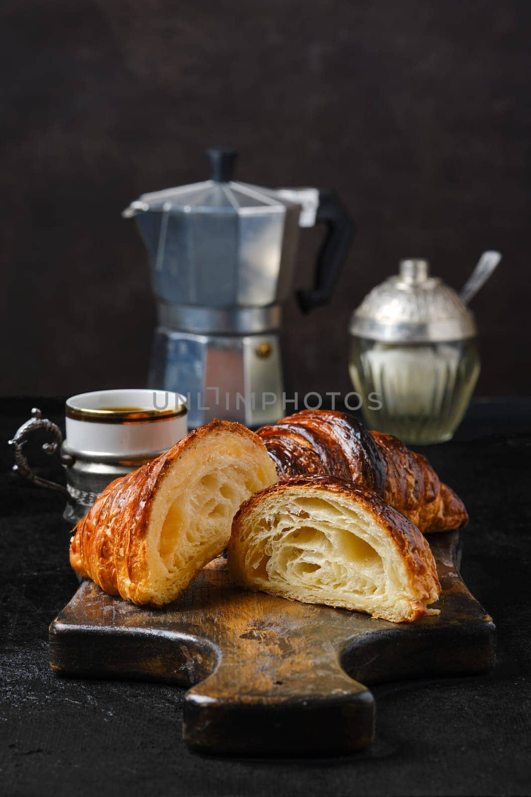 Classic breakfast with croissant cut on half and espresso coffee