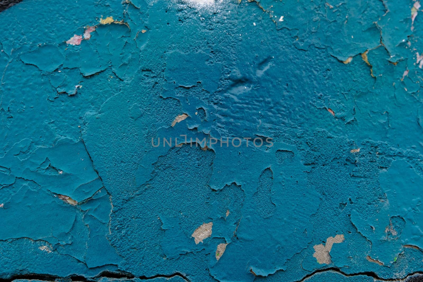 Colorful wall background with damaged paints of blue.