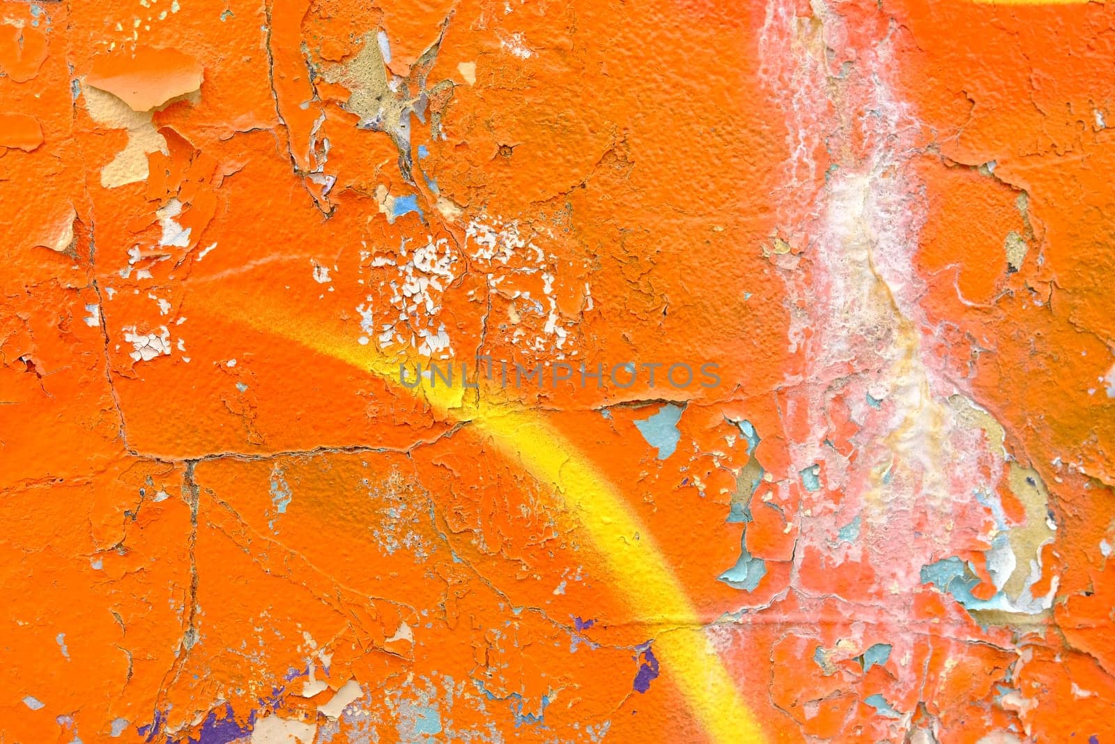Colorful wall background with damaged paints of orange.