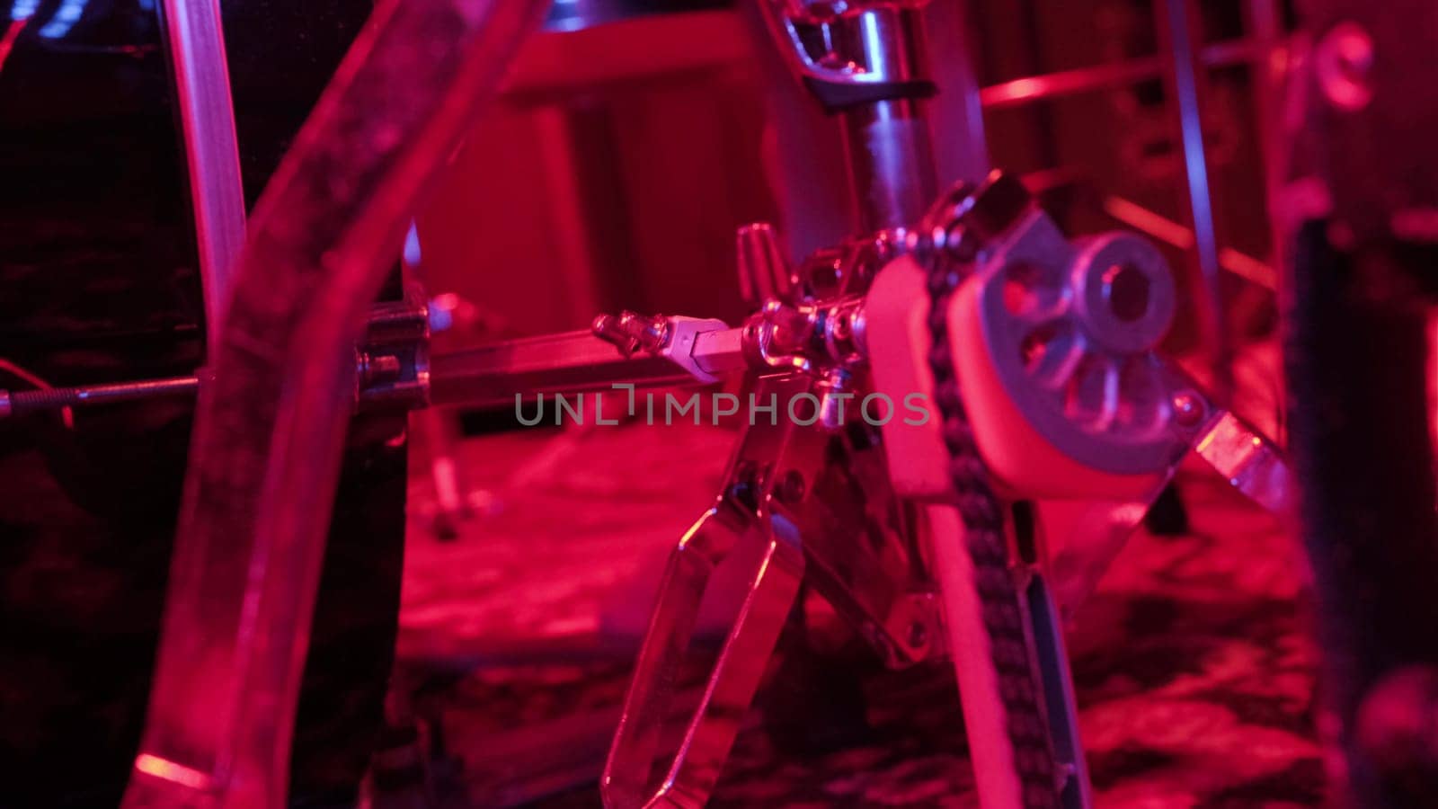 Drummer rehearsing on drum barrel before rock concert. Man recording music on drum set in studio in red light.