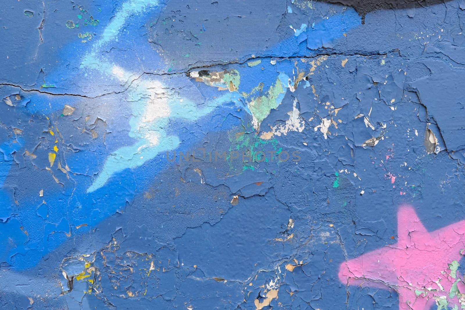 Colorful wall background with damaged paints of blue.