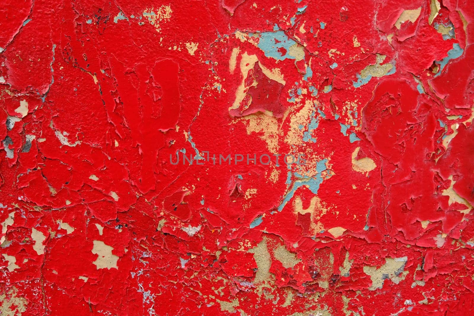 Colorful wall background with damaged paints of red.