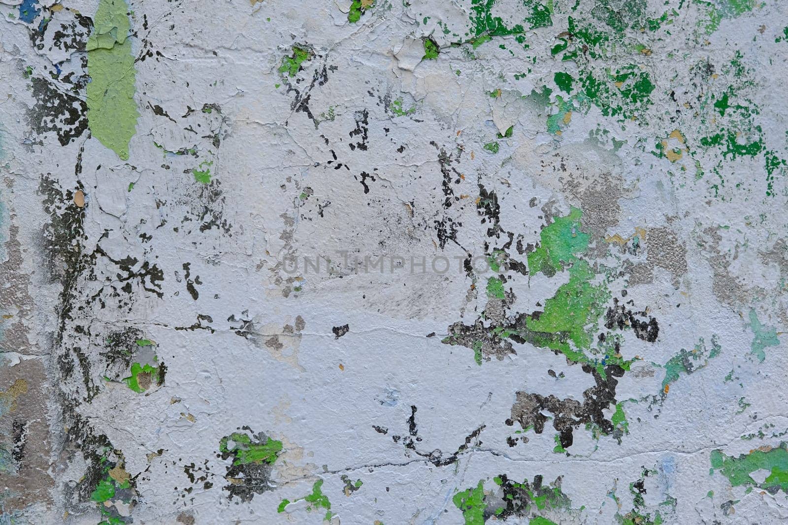 Colorful wall background with damaged paints of gray and green.