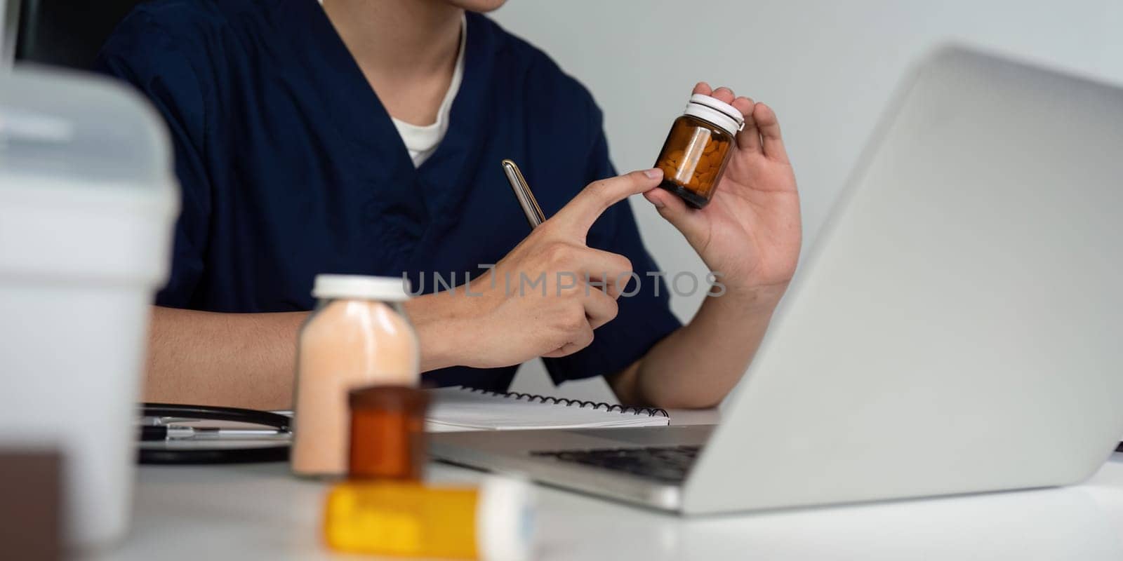 A medical student examines medication bottles and takes notes, demonstrating commitment to learning about pharmaceuticals and patient care.