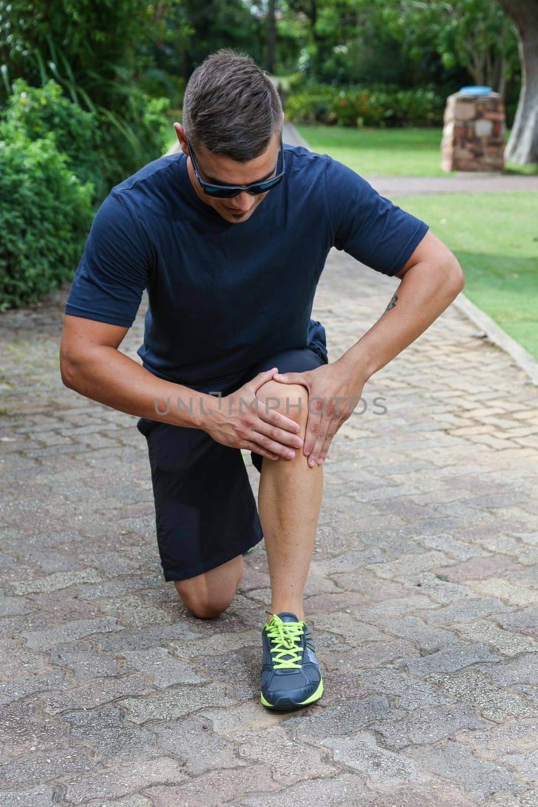 Handsome young athlectic man inspecting his sore knee