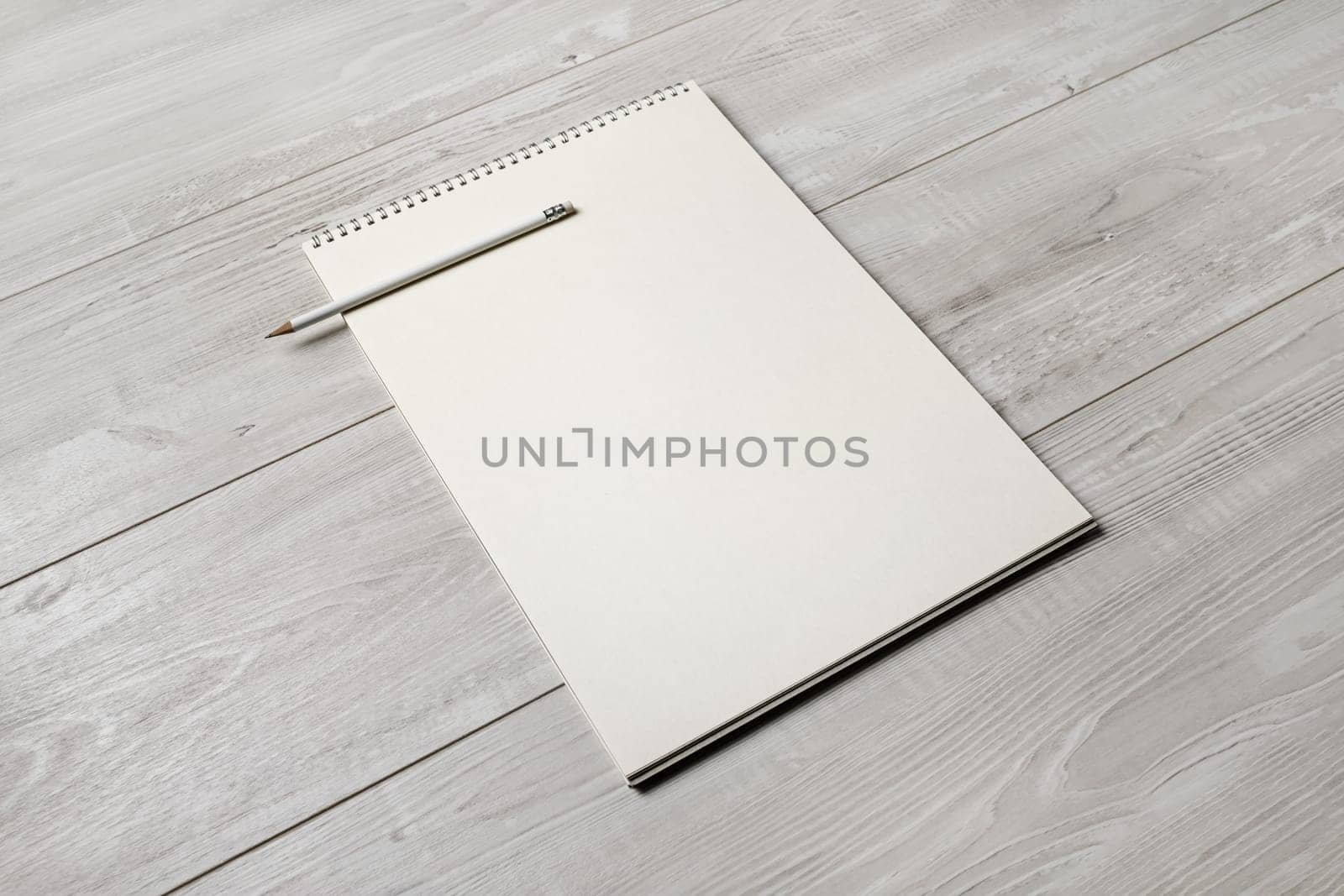 Photo of blank notepad and pencil on light wooden background. Responsive design template.
