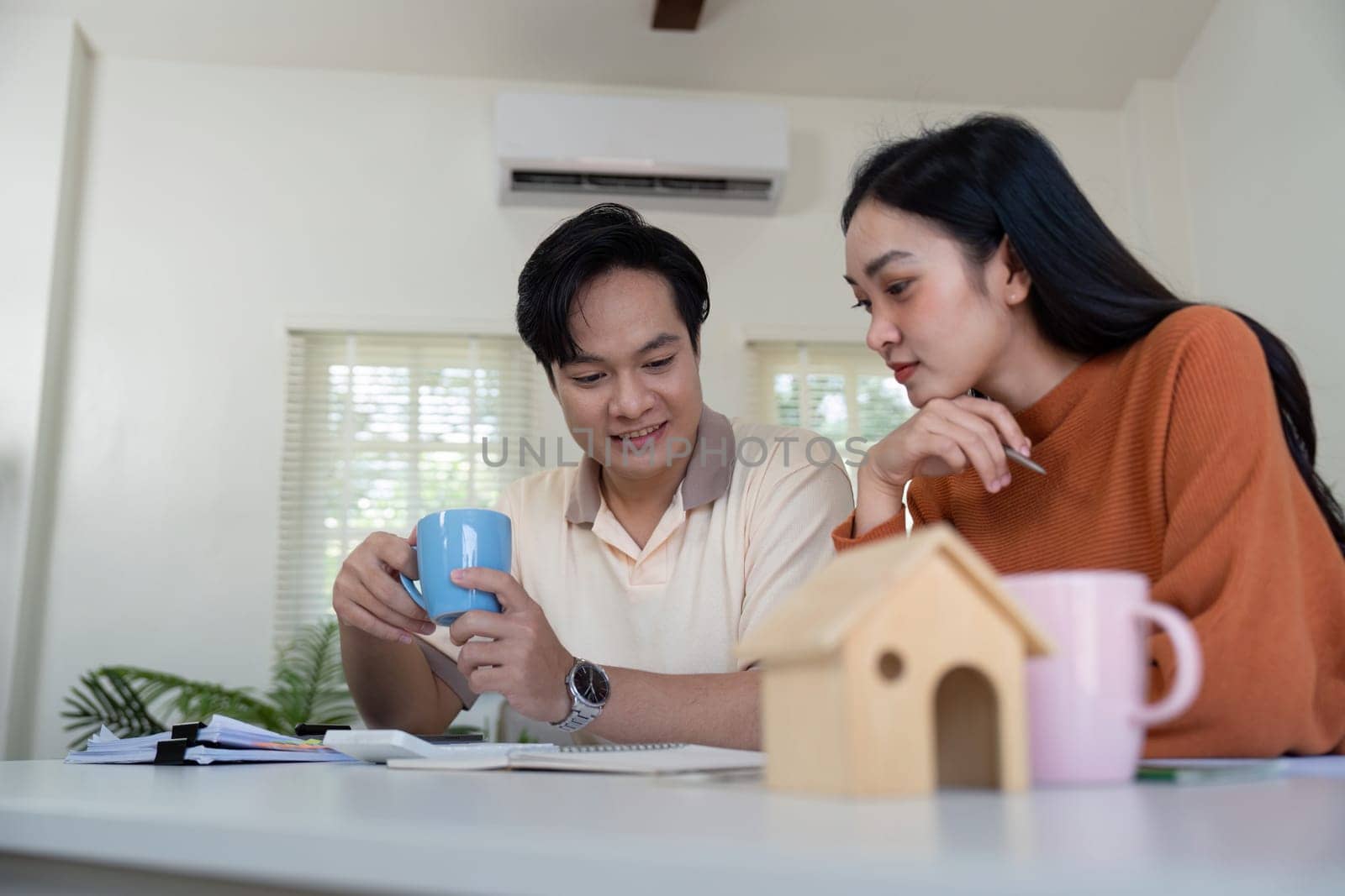 A couple engages in a thoughtful discussion about their financial plans while enjoying coffee and reviewing documents at home.