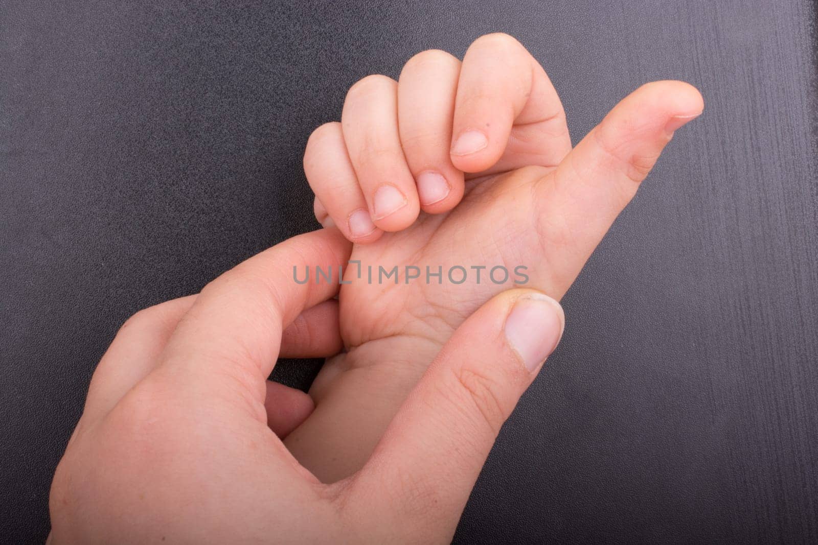 Toddler hand with dark color background