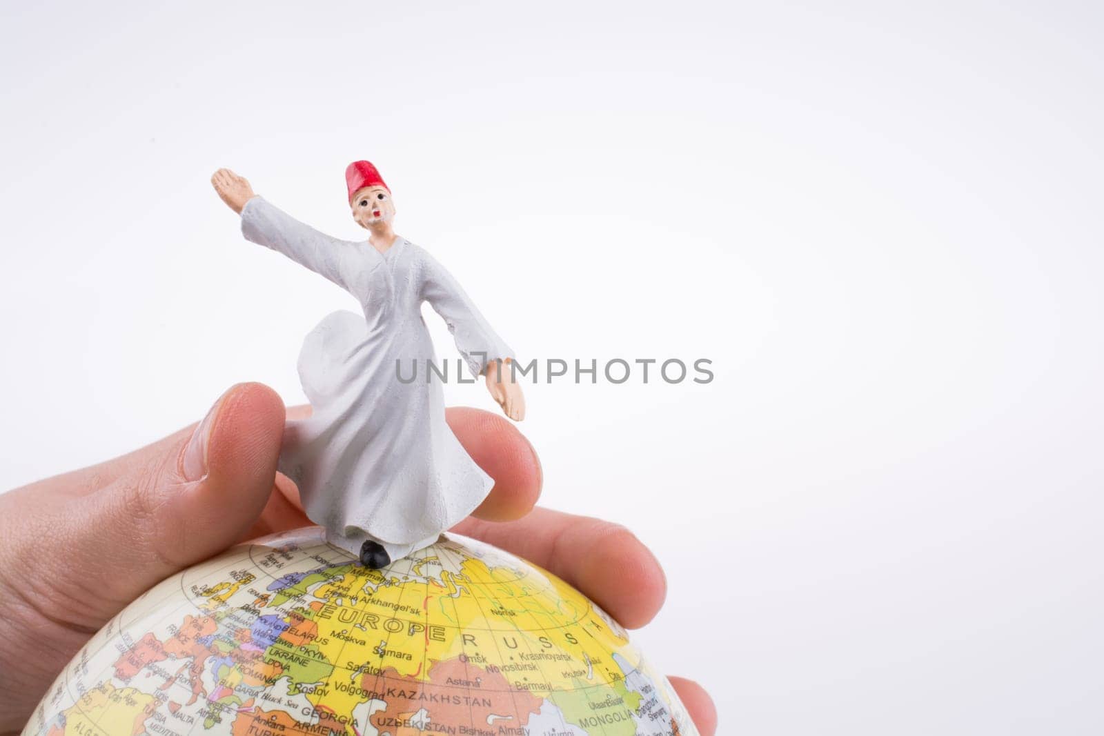 Hand holding a Sufi Derviş on a globe