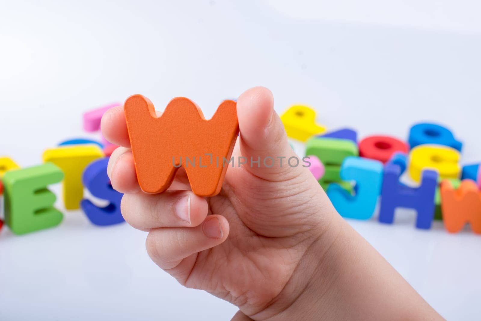 Hand holding letter cube W of made of wood