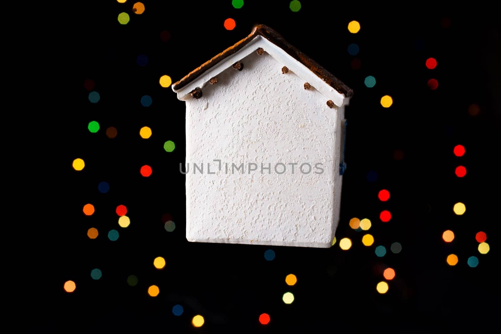 Little model house on a bokeh ligh ton a dark background