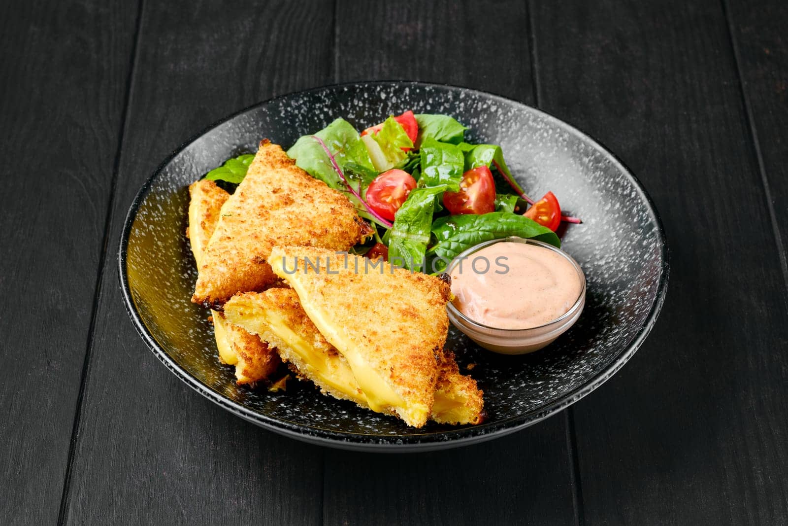 Sandwich with melted cheddar and salad on a plate