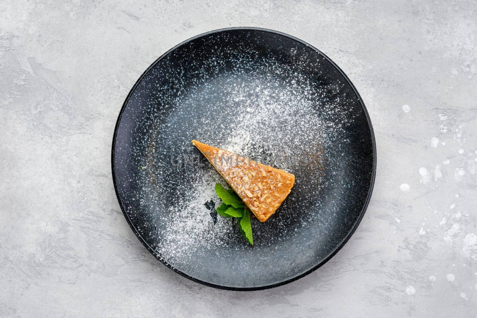 Top view of triangular piece of caramel cheese cake on a plate