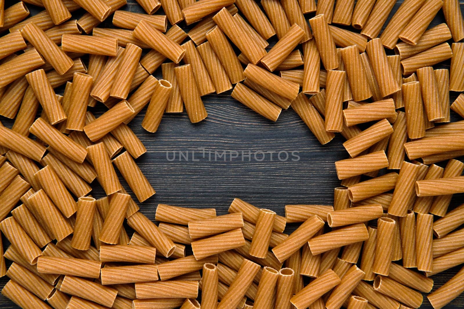 Top view of tortiglioni pasta with copy space place. Grooved helical tube pasta.