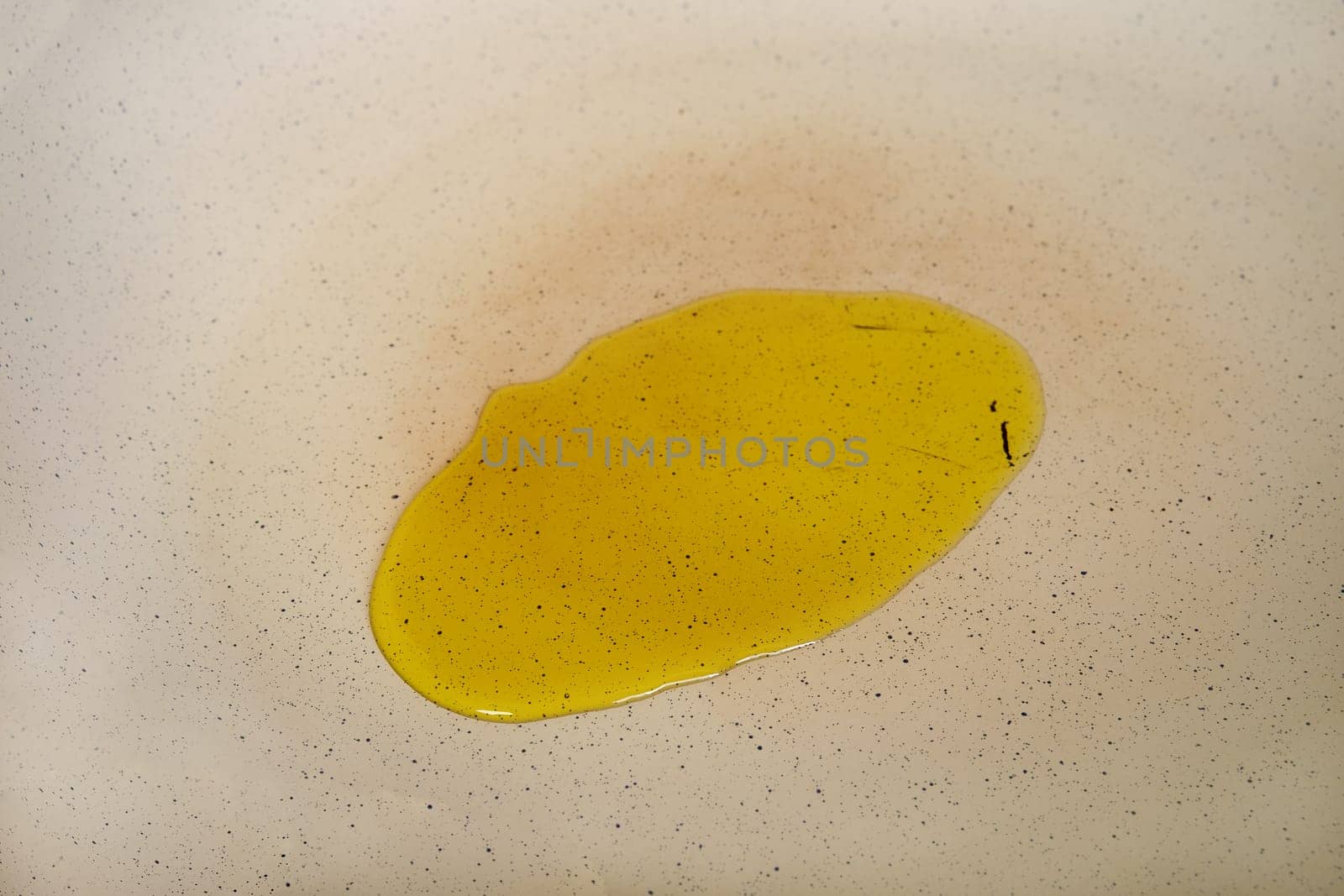 Olive oil on the surface of a frying pan, closeup view