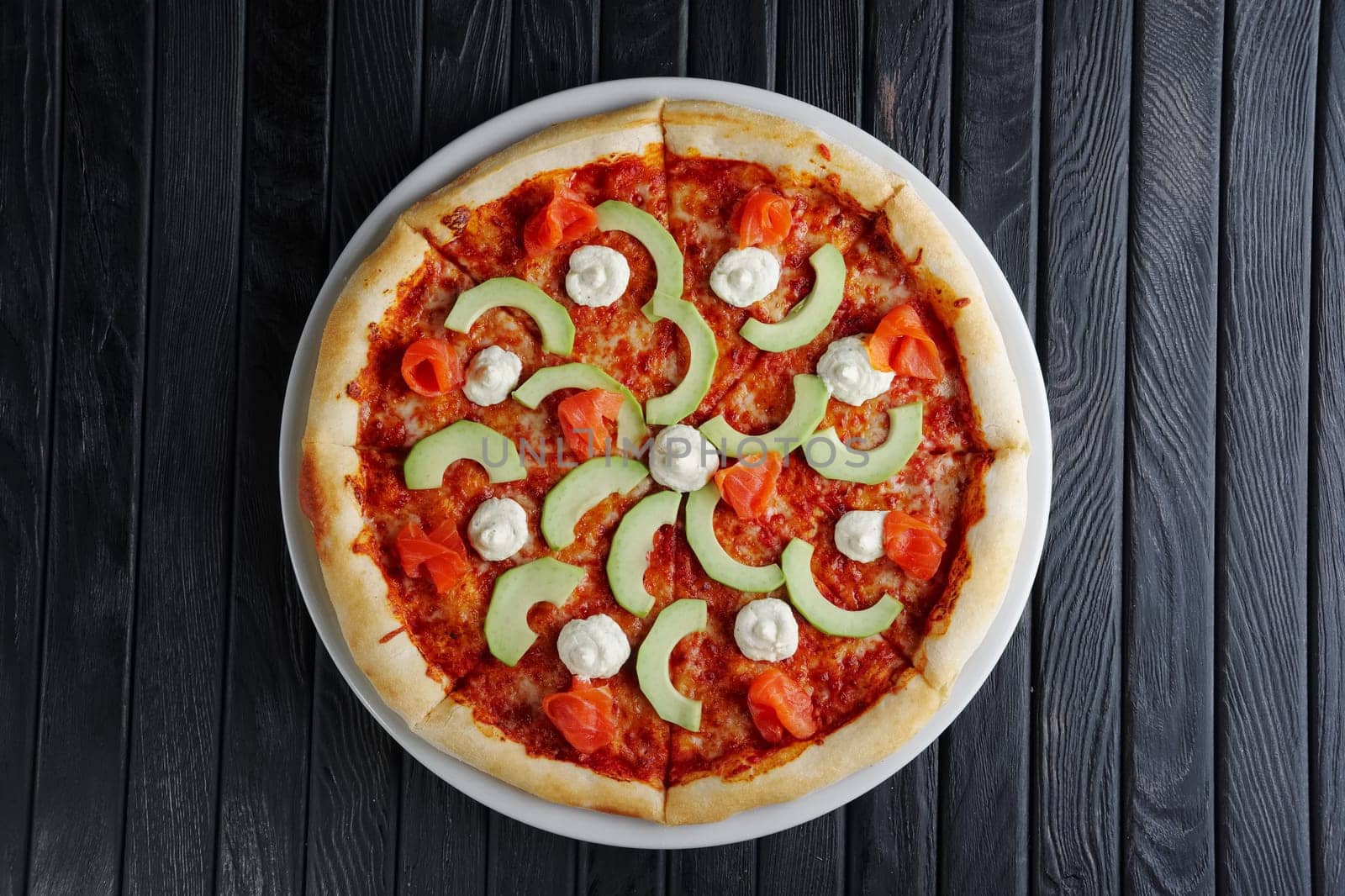 Pizza with salmon, avocado and feta cheese