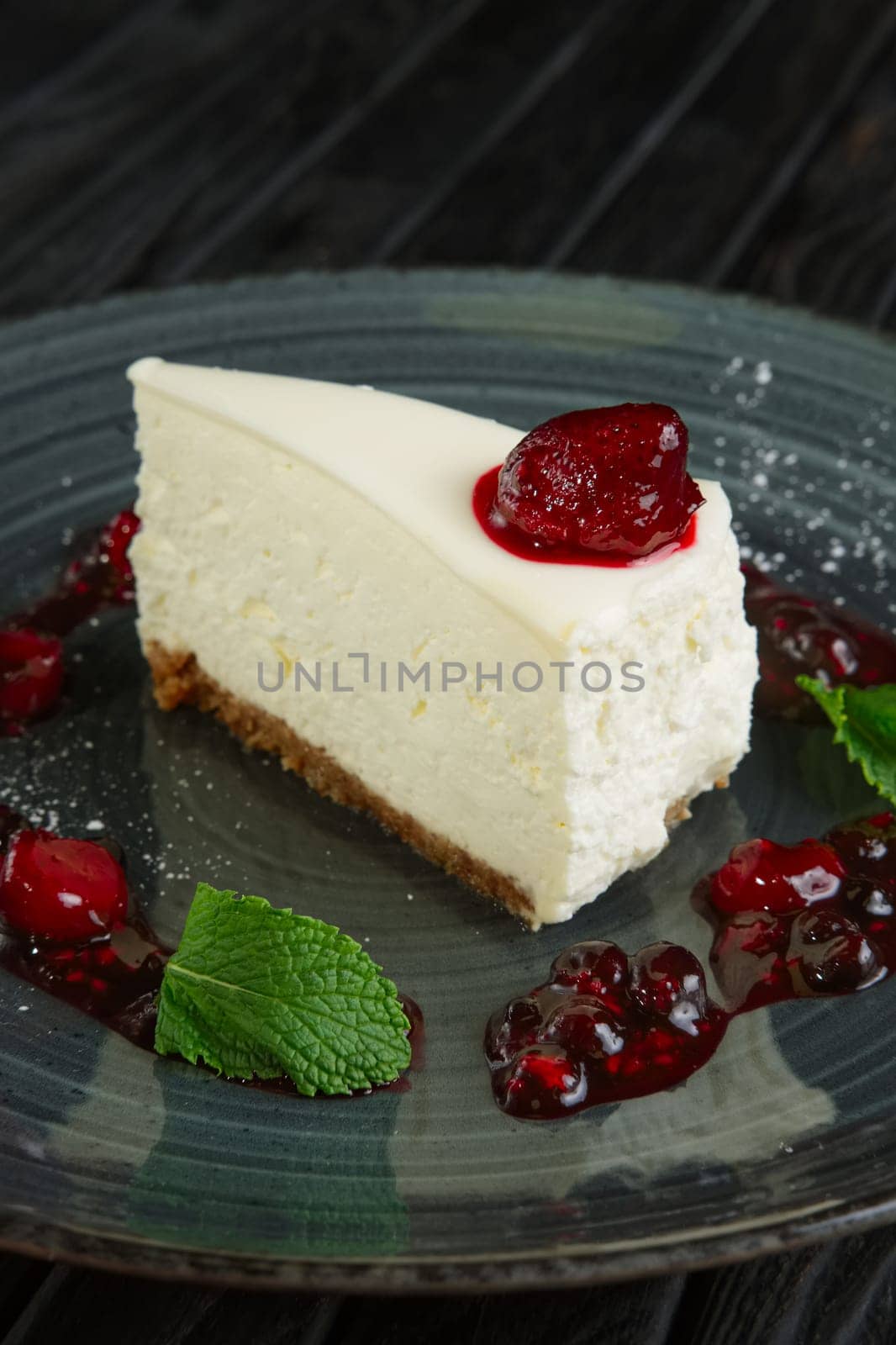 Closeup view of cheese cake decorated with cherry, strawberry and raspberry