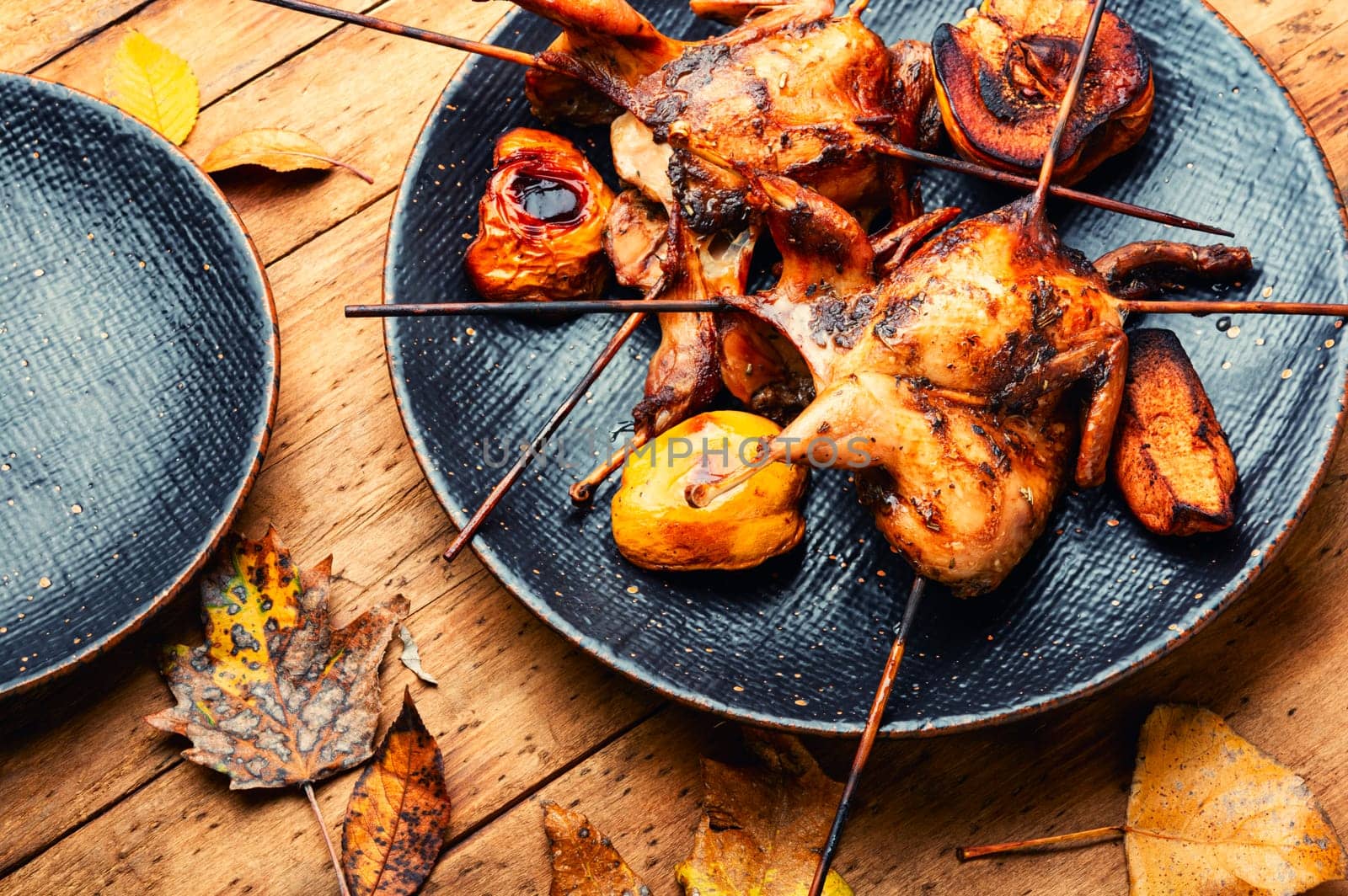 Shish kebab of quail and autumn quince on wooden skewers