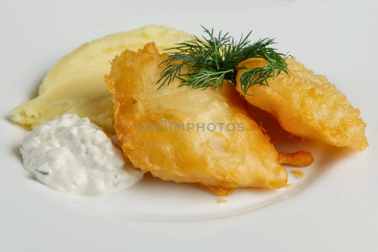 Close up view of fish fillet in batter with mashed potato