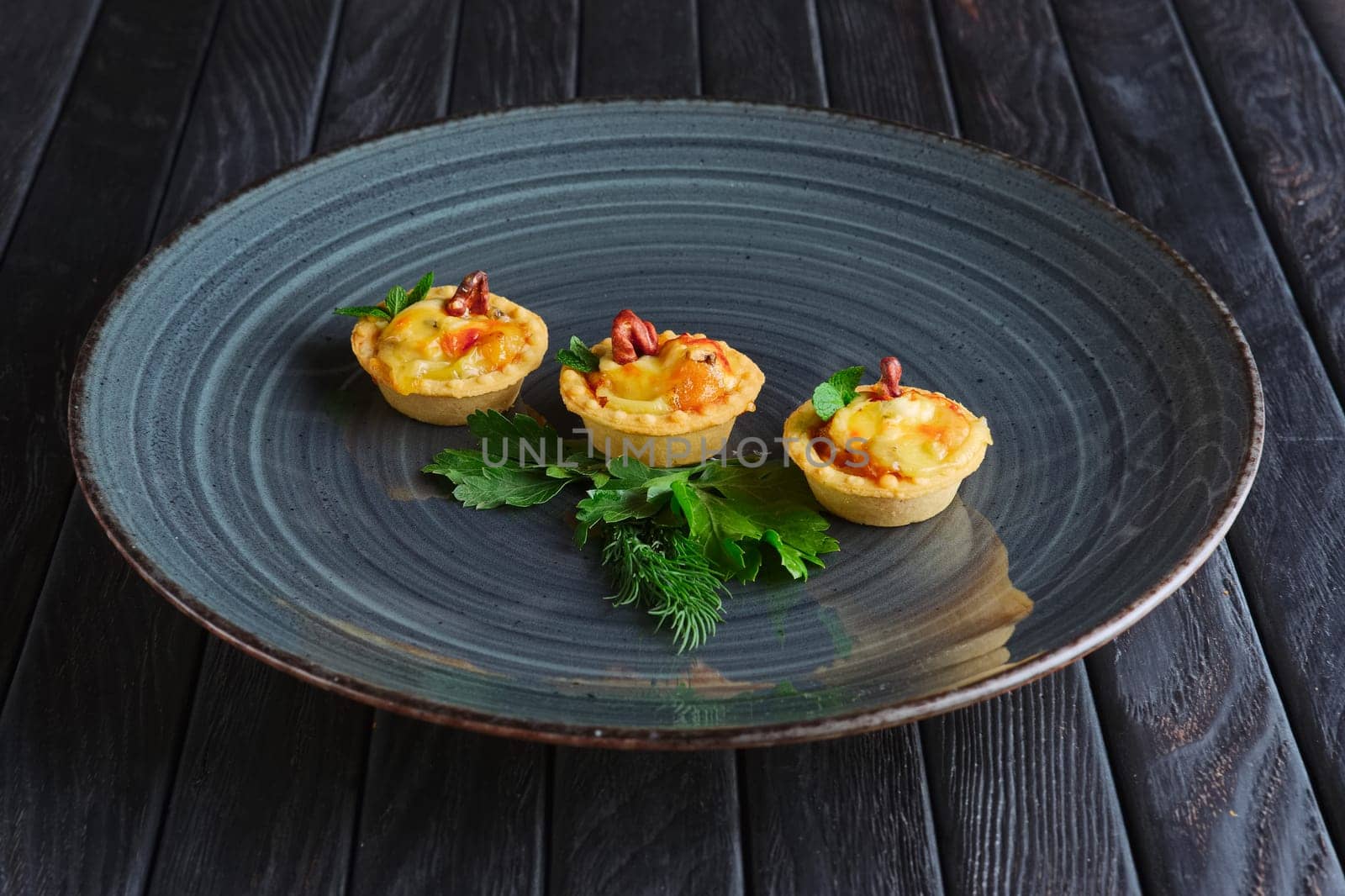 Appetizer for reception. Tartlet with bacon, melted cheese and mushroom