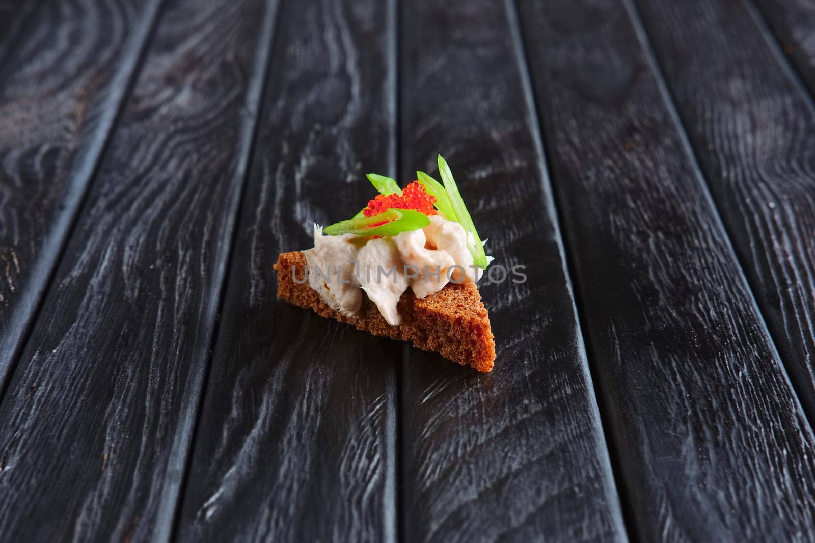 Appetizer for reception.Piece of brown bread with fish pate and green onion