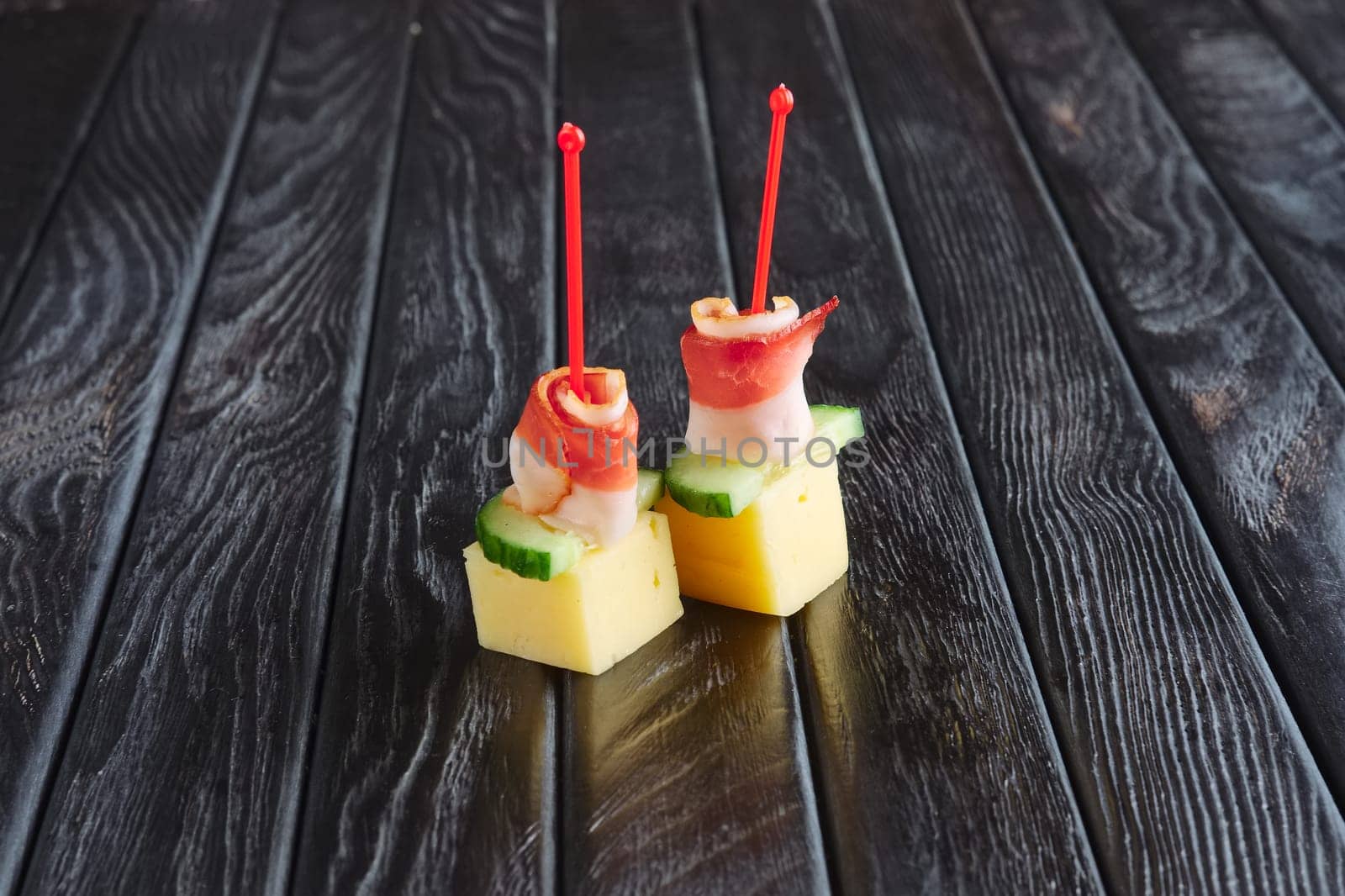 Appetizer for reception. Cheese, bacon and cucumber on skewer