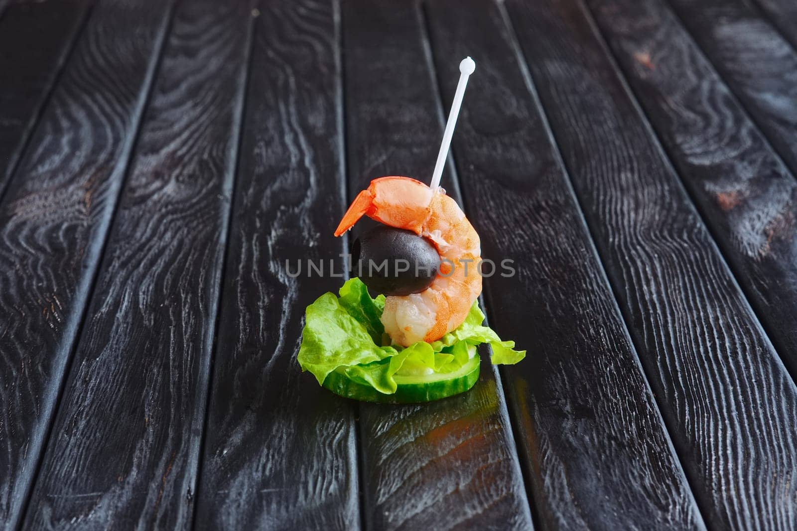 Appetizer for reception. Slice of cucumber with shrimp and olive on skewer