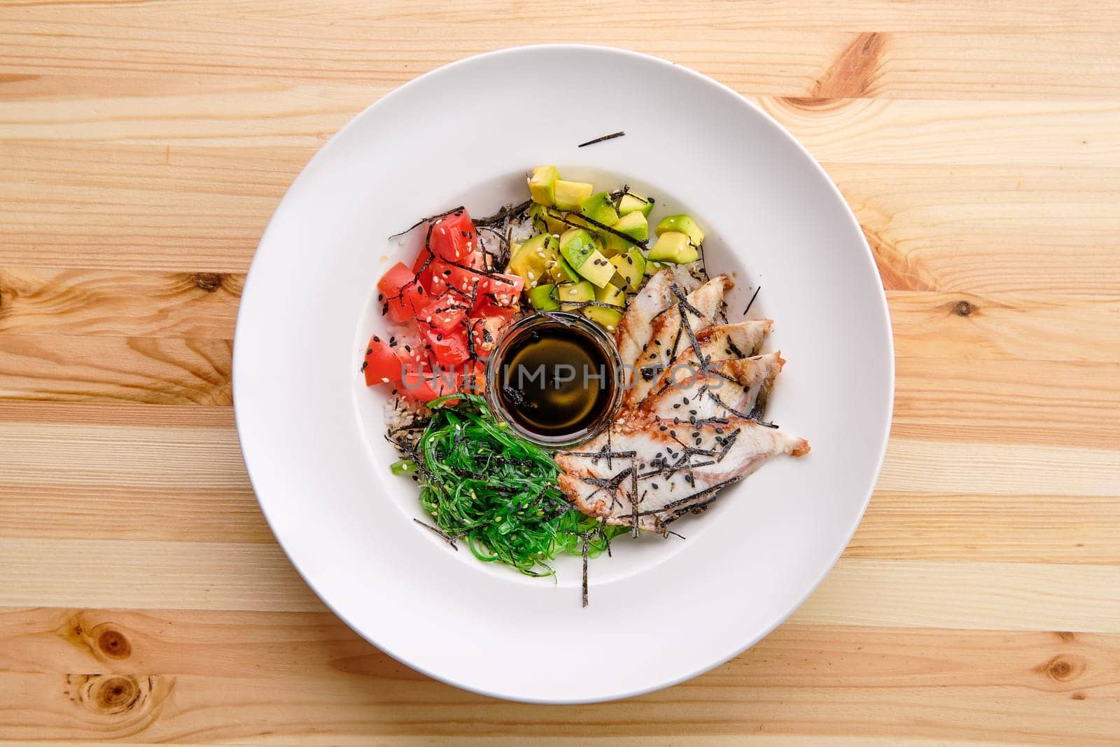 Unagi sashimi rice bowl with avocado, seawed, tomato and soy sauce