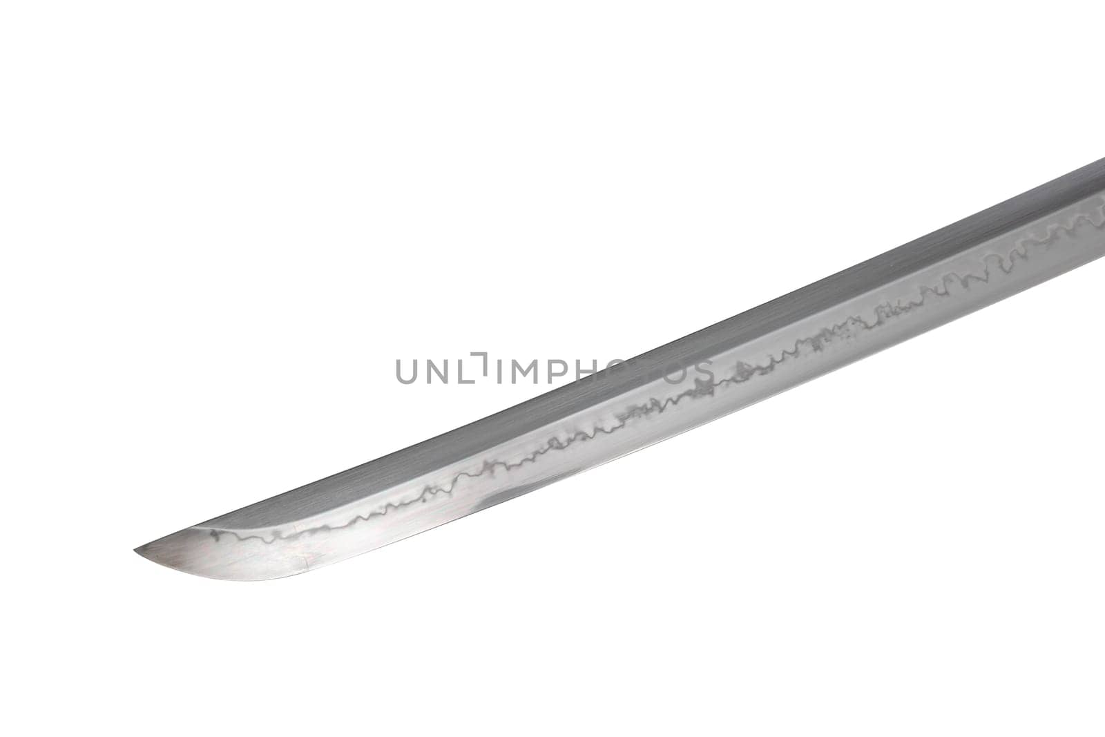 Japanese sword blade on white background. Soft focus. The wavy pattern on the blade edge is a line of hardness that a blacksmith makes so that the blade doesn't break. Choji Hamon style.