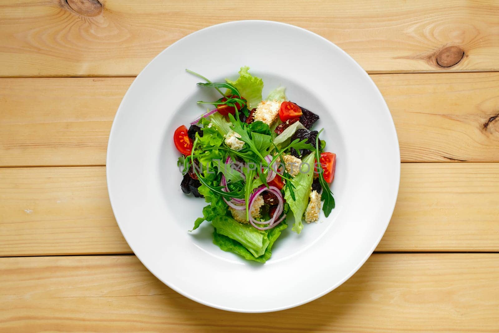 Overhead view of salad with onion, beetroot, tomato, feta and sesame