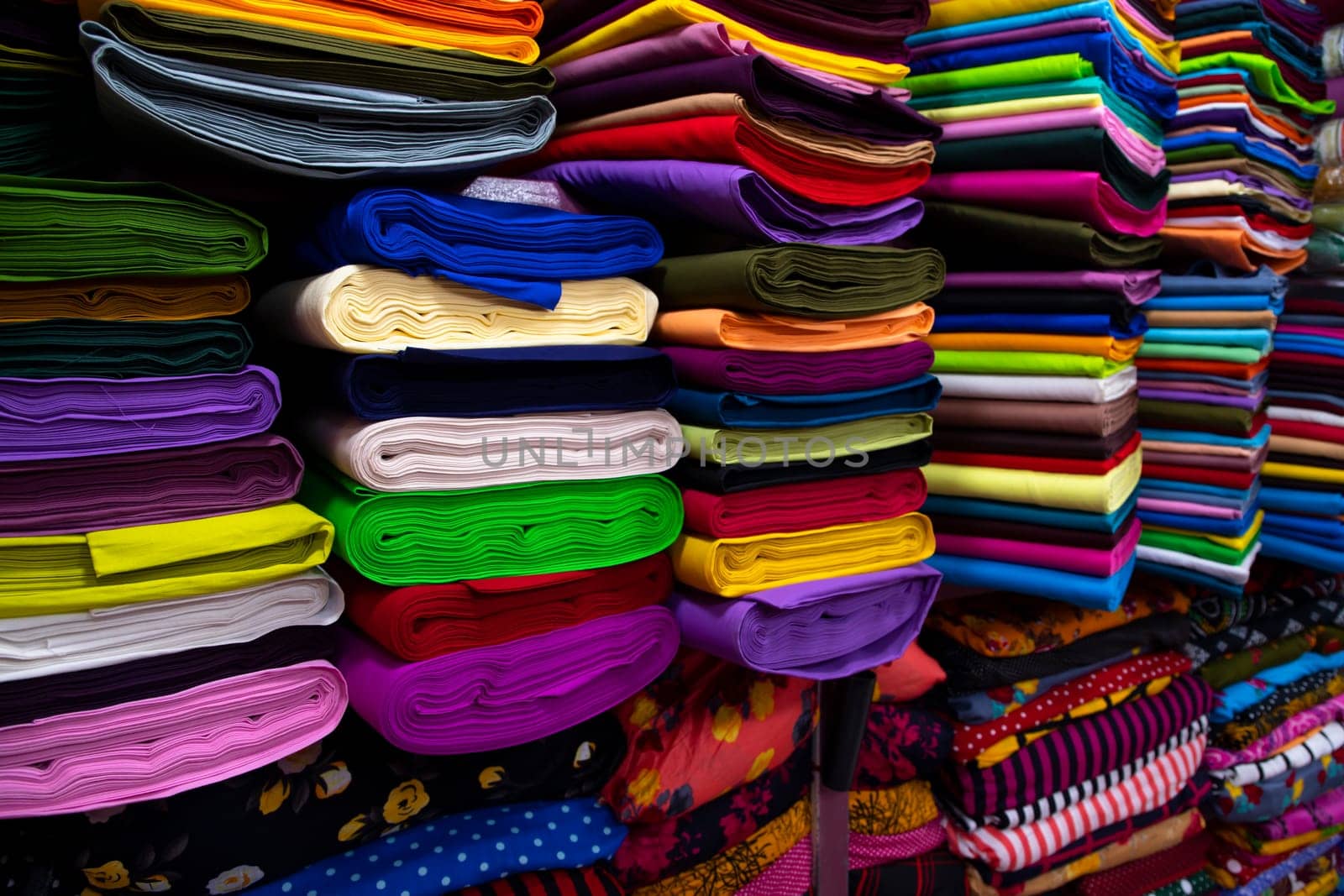Artistic variety shade tone colors Textile Fabrics stacked on retail Shop Shelf to sale