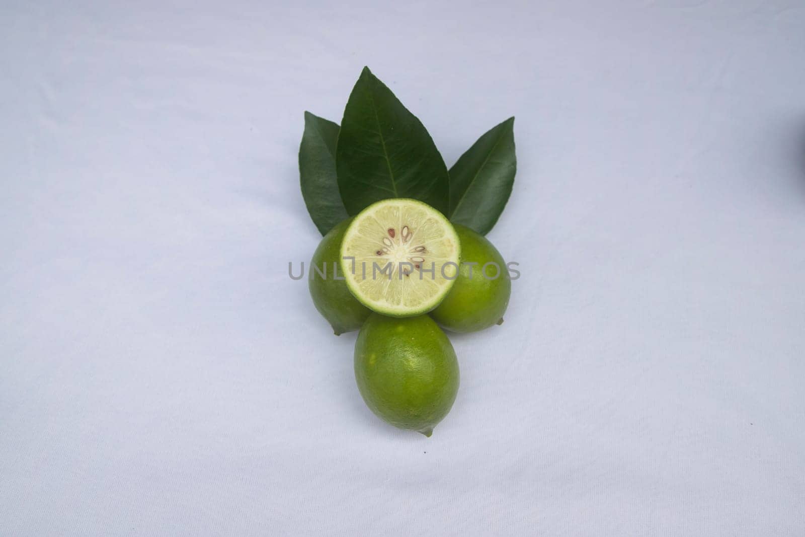 Fresh green lemon slice pieces with leaf. Testy lemon fruits. Refreshing summer drink ingredient