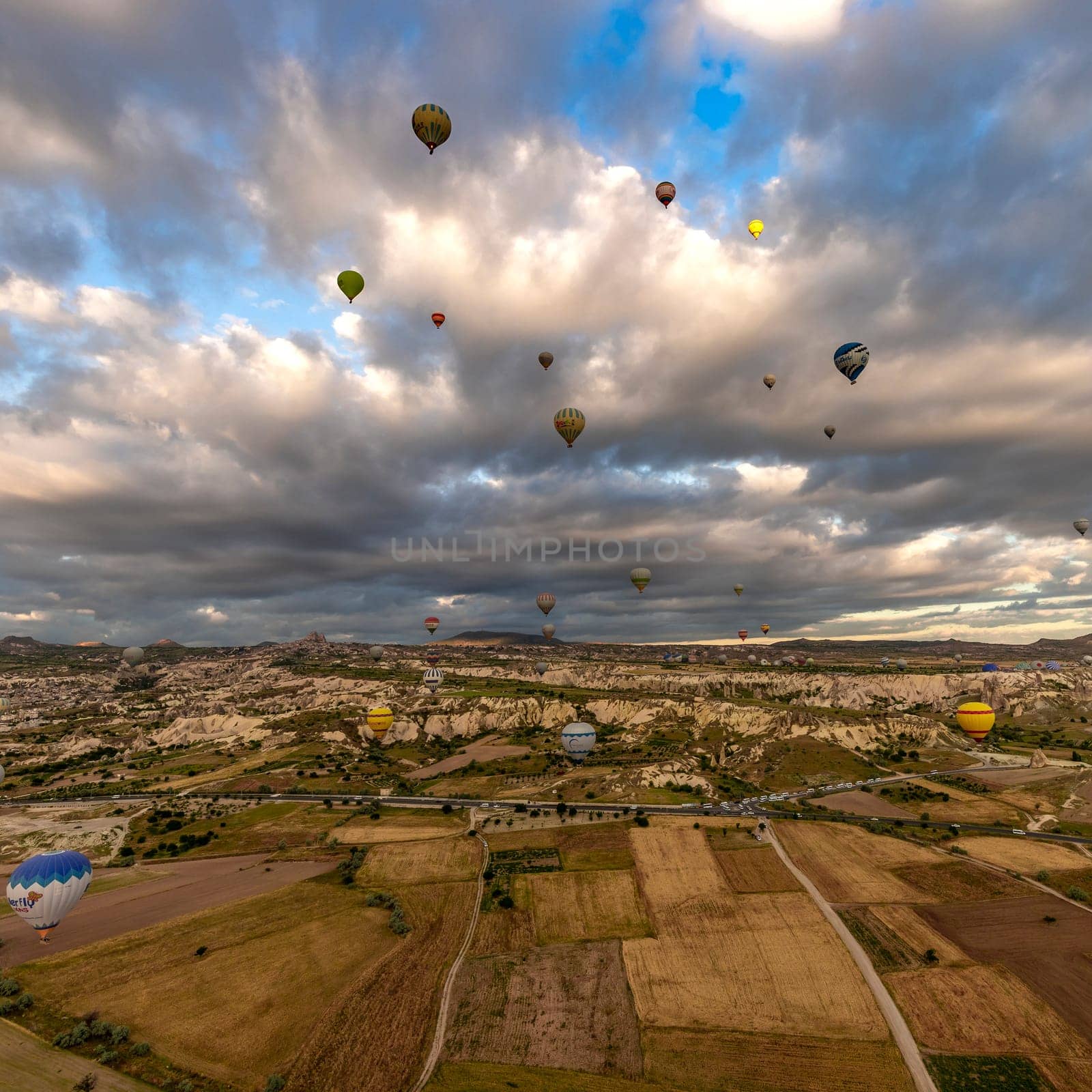 GOREME/TURKEY - June 26, 2022: colorful hot air balloons fly at sunrise near goreme, aerial view