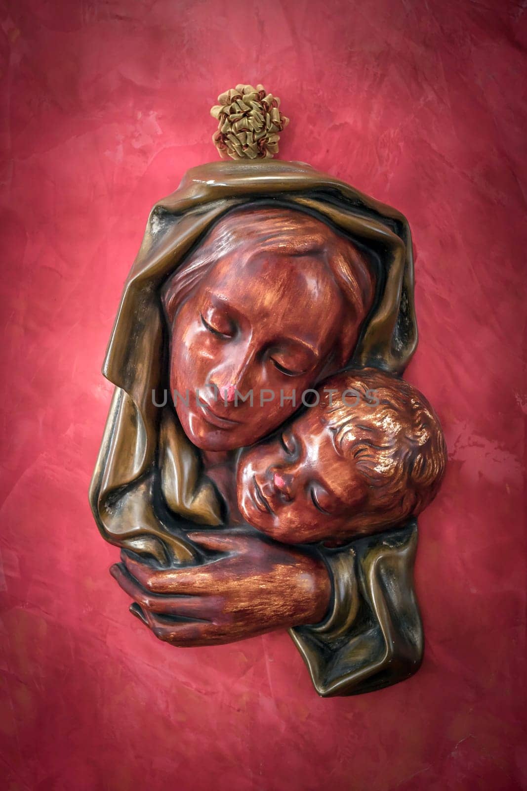 Red Bas relief madonna with child in embrace.