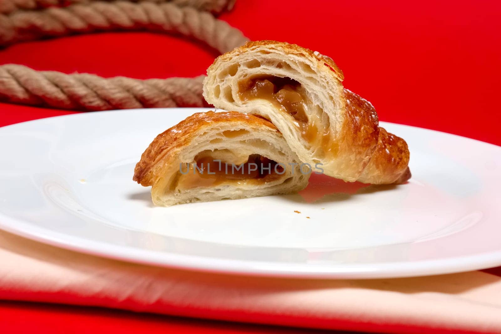 Fresh baked croissant on plate divided on pieces
